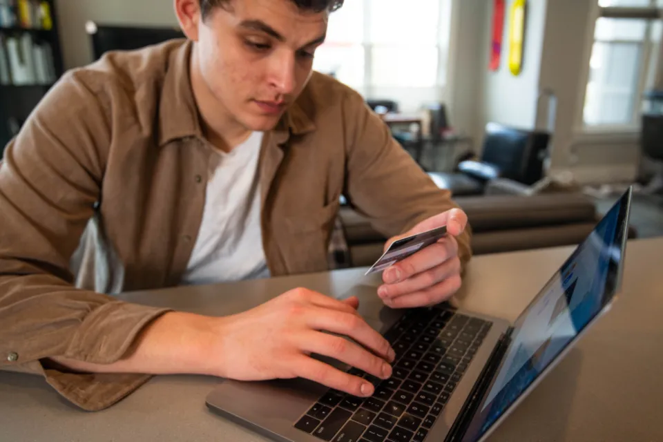 Man buying something online with a credit card and a laptop