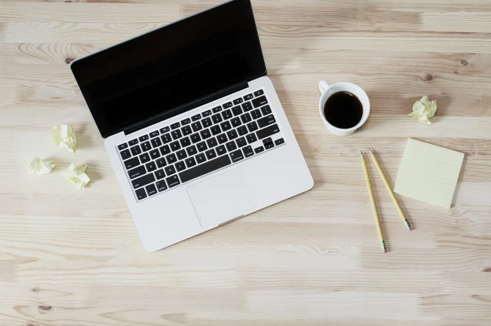 Laptop, coffee and sticky notes on a wooden desk